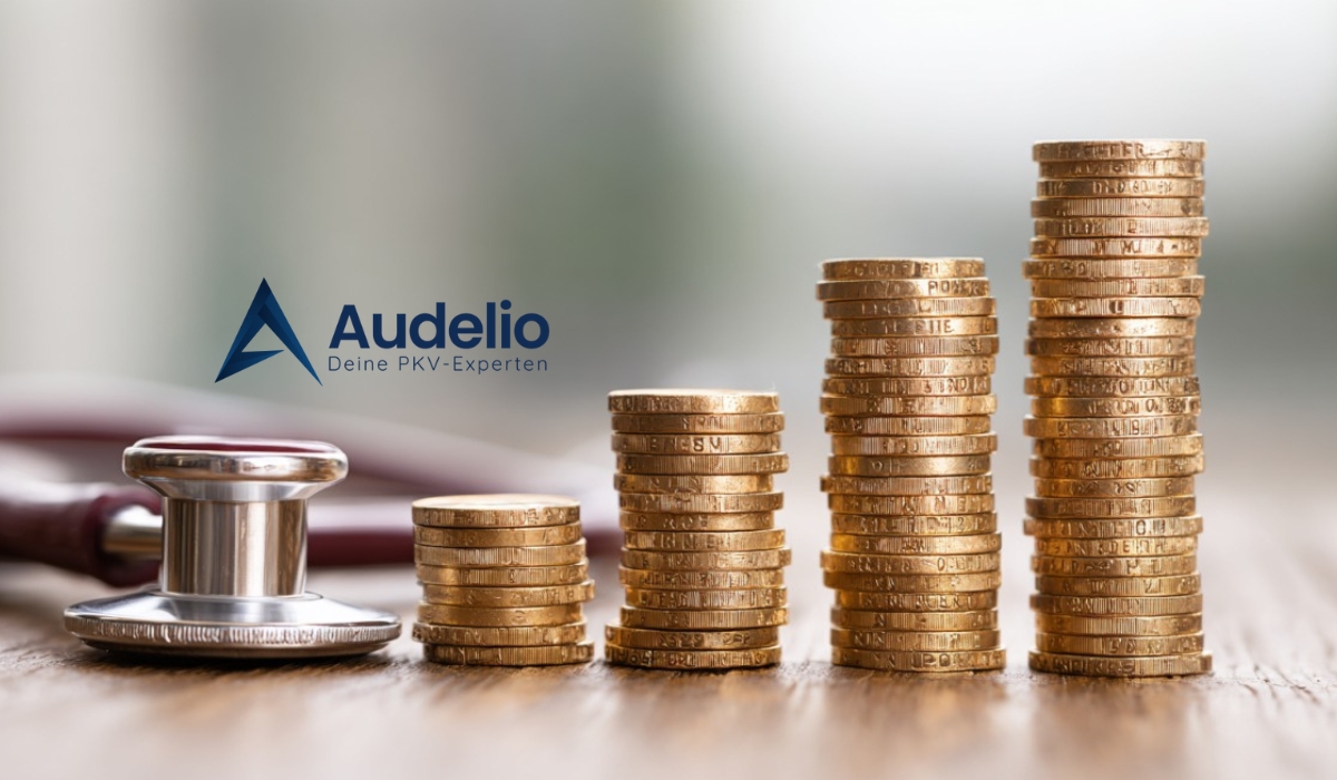 Stethoskop neben aufgestapelten Euromünzen mit Audelio-Logo – Symbolbild für steigende Gesundheitskosten
